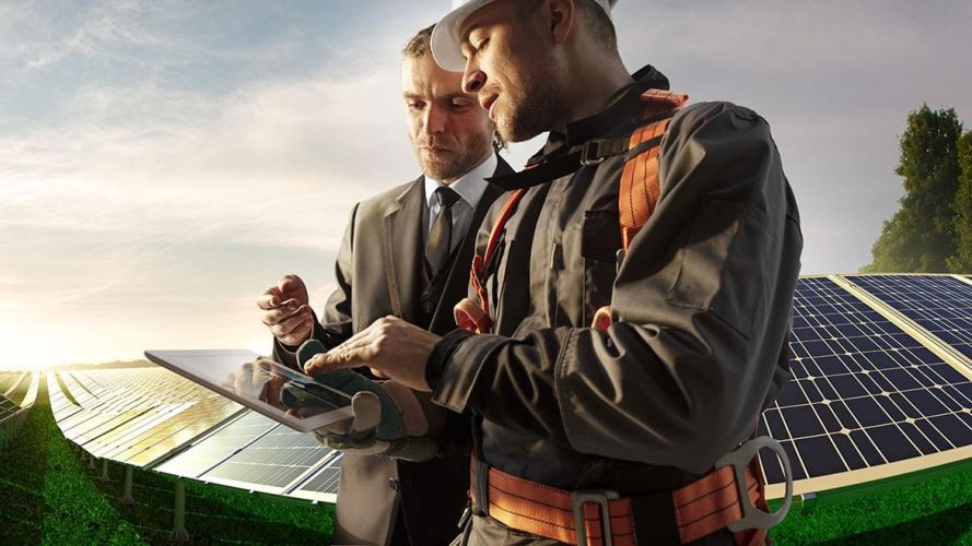 Construction worker and businessman in front of solar panels